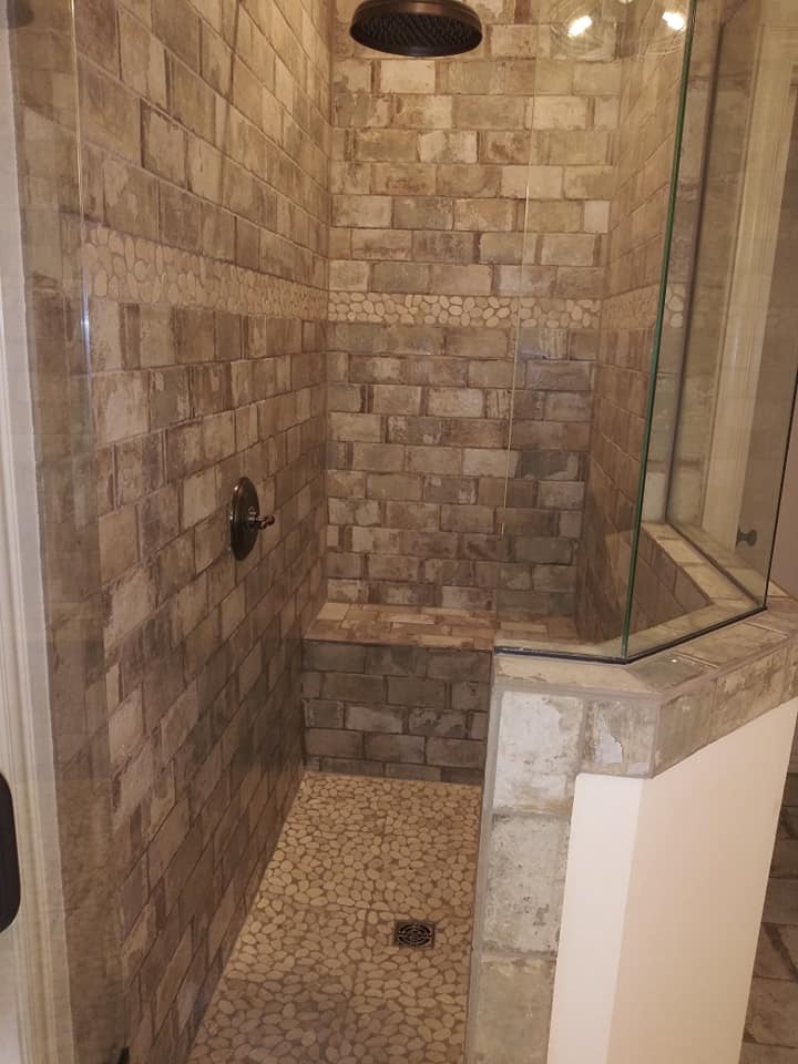 A walk in shower with stone walls and floor.