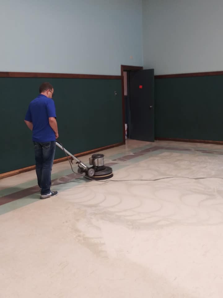 A man is using a machine to clean the floor.