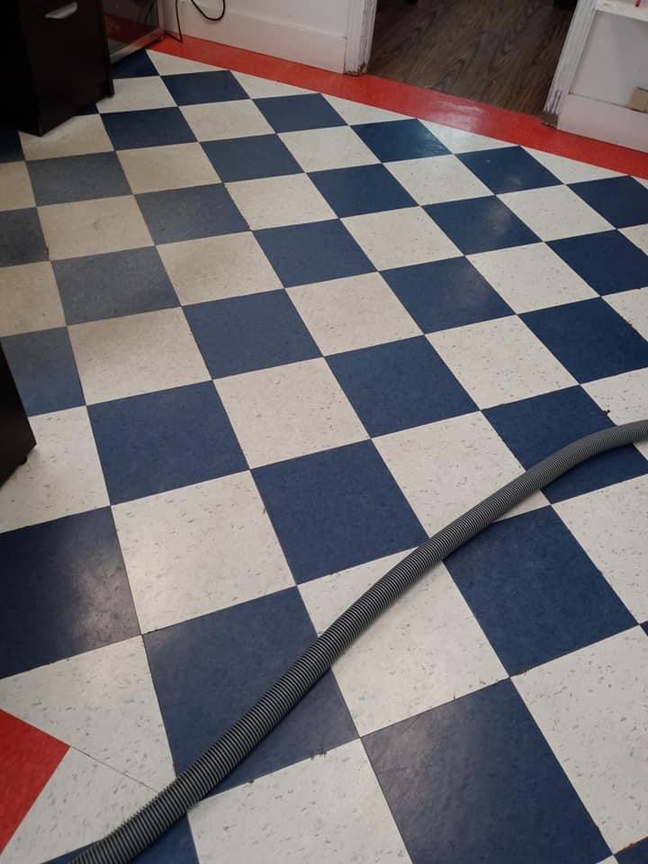 A black and white checkered floor with a hose.