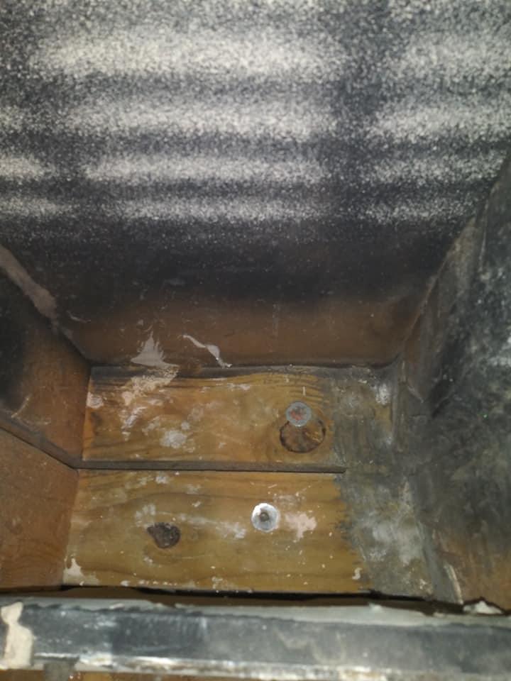 A dirty air duct with mold growing on it.