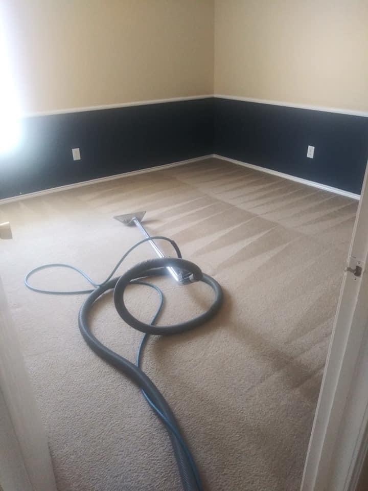 A room with a carpet cleaning machine on the floor.