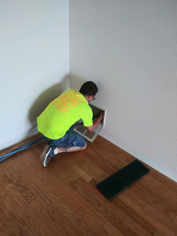 A man in yellow shirt fixing a wall.