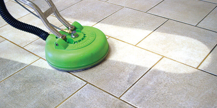 A green machine is cleaning the floor